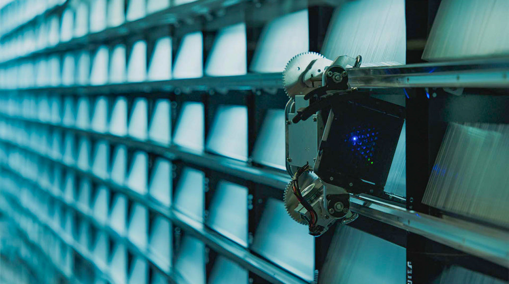 Roboterarm bewegt sich entlang von Regalen in einer futuristischen Datenbibliothek mit leuchtenden Elementen.
